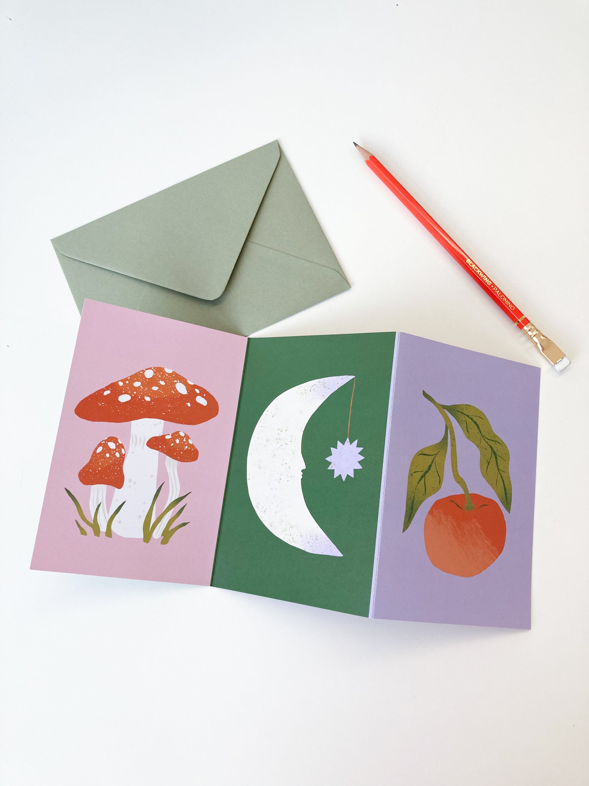 Art Concertina Christmas card showing mushrooms, a moon and a tangerine. 